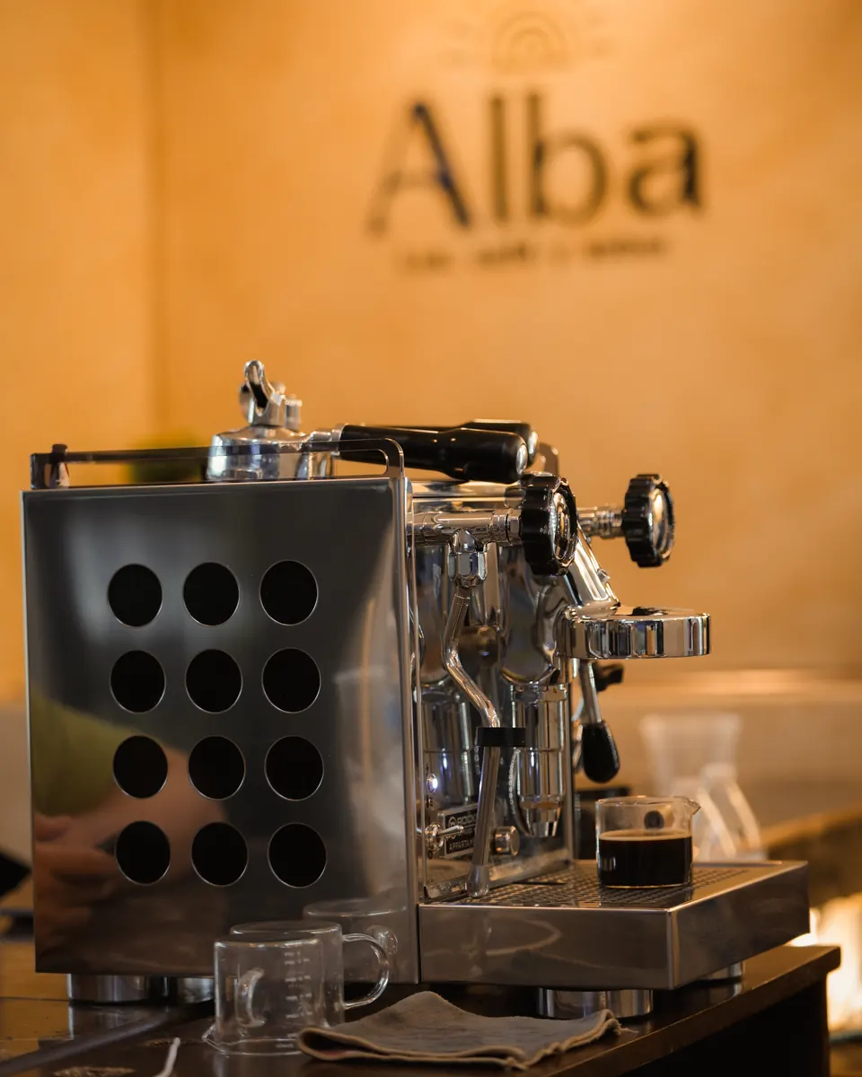 Máquina de espresso de Alba con el letrero al fondo